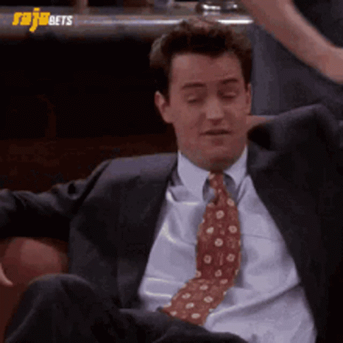 Man in Suit and Tie Sitting on Couch With Legs Crossed