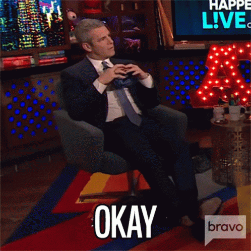 Man in Suit and Tie Sitting With Feet Up and Okay Text