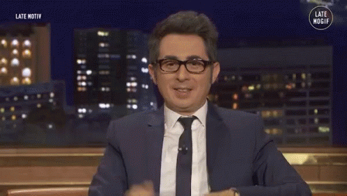 Man In Suit And Tie Smiling And Waving GIF
