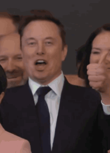 Man in Suit and Tie Smiling at Crowd