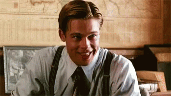 Man in Suit and Tie Smiling at Desk