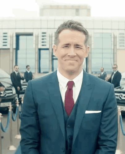 Man in Suit and Tie Smiling in Front of Building