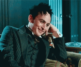 Man In Suit And Tie Smiling On Couch GIF