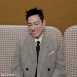 Man in Suit and Tie Smiling on Couch