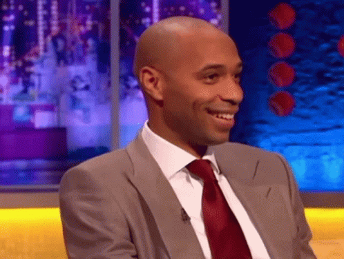 Man in Suit and Tie Smiling on Stage
