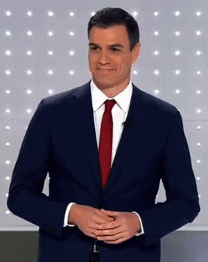 Man in Suit and Tie Smiling With Hands Folded