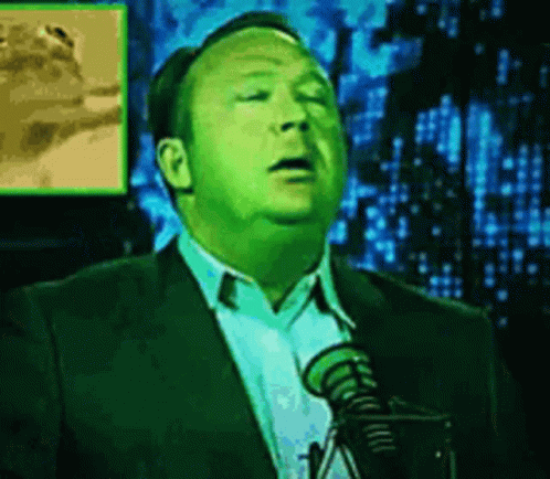 Man in Suit and Tie Speaking into Microphone