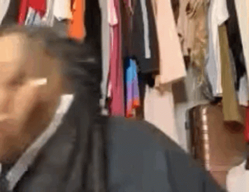 Man In Suit And Tie Standing By Closet GIF