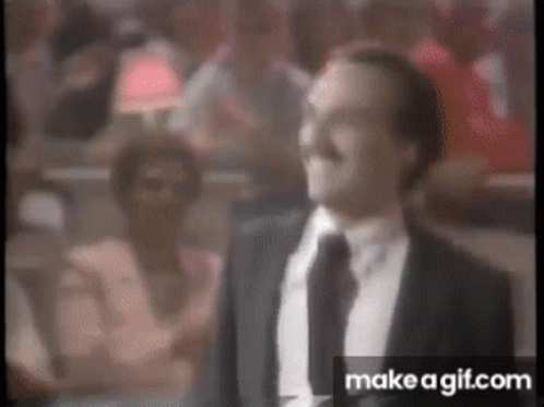 Man in Suit and Tie Standing in Front of Crowd