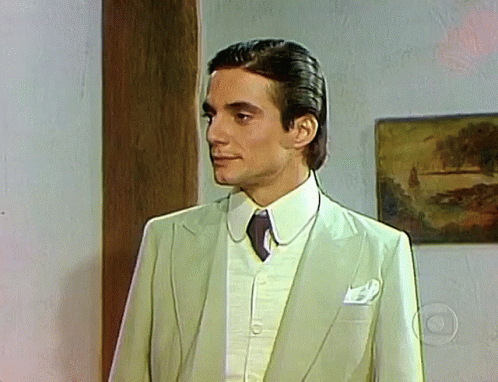 Man In Suit And Tie Standing In Front Of Picture GIF