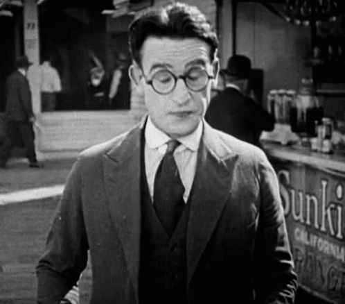 Man in Suit and Tie Standing in Front of Sunkist Sign