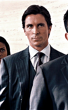 Man in Suit and Tie Standing in Front of Woman