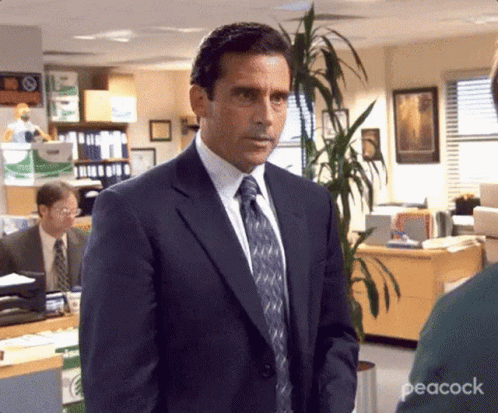 Man in Suit and Tie Standing in Office with Plant