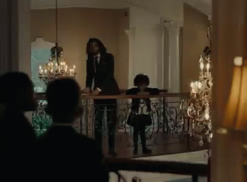 Man In Suit And Tie Standing On Balcony With Girl GIF