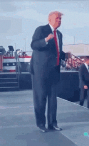 Man In Suit And Tie Talking On Stage GIF