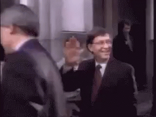 Man In Suit And Tie Walking Down Hallway GIF
