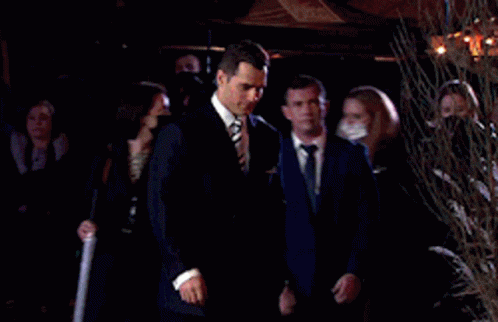 Man in Suit and Tie Walking in Front of Crowd