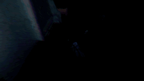 Man in Suit and Tie Walking Through Dark Room