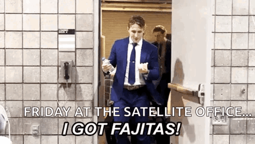 Man in Suit and Tie Walking Through Door Holding Bottle of Water