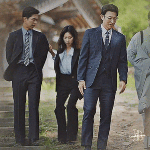Man In Suit And Tie Walking With Two Men And Woman GIF