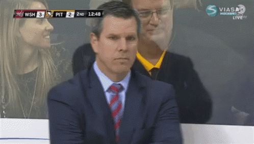 Man in Suit and Tie Watching Hockey