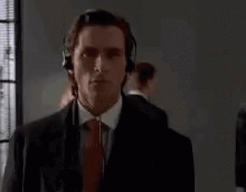 Man In Suit And Tie Wearing Headphones By Window GIF
