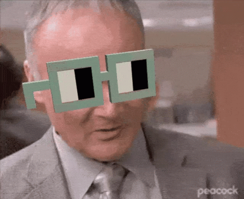 Man in Suit and Tie Wearing Peacock Sunglasses