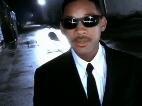 Man in Suit and Tie With Cross Sunglasses
