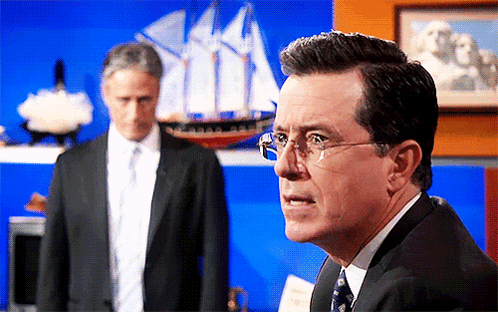 Man in Suit and Tie with Glasses by Model Ship