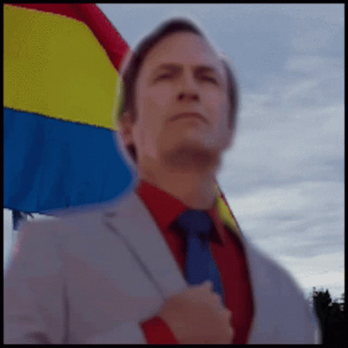 Man in Suit and Tie with Rainbow Flag