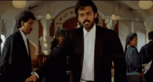 Man In Suit And Tie With Suresh Productions Logo GIF