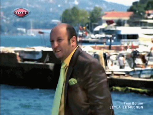 Man in Suit and Tie With TRT1 Logo Above Water
