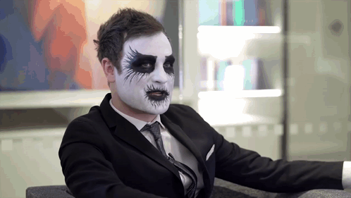 Man in Suit and Tie With White Face Paint