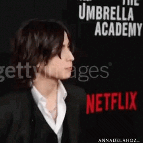 Man in Suit and White Shirt at Netflix Sign
