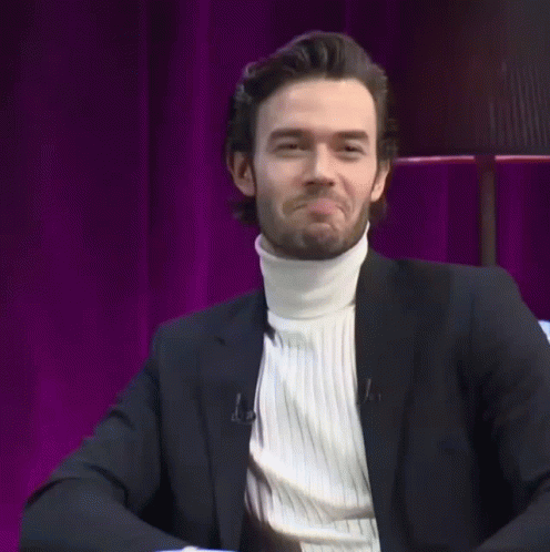 Man in Suit and White Turtleneck Smiling