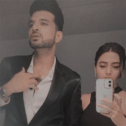 Man in Suit and Woman in Black Dress Taking Selfie