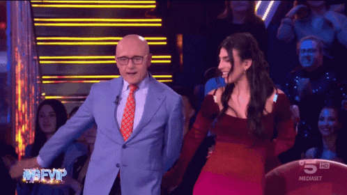 Man in Suit and Woman in Red Dress on TV Saying 5 HD