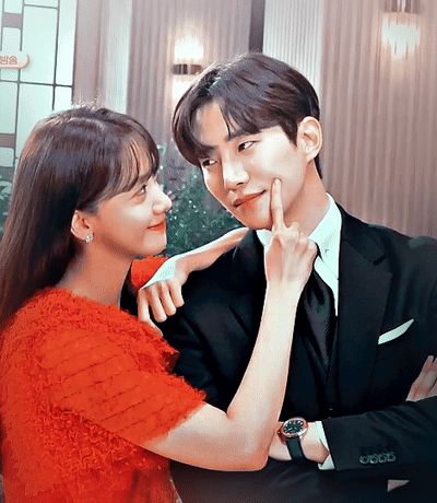 Man In Suit And Woman In Red Dress Touching His Face GIF