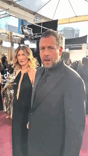 Man in Suit and Woman on Red Carpet