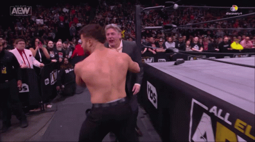 Man in Suit and Wrestler in AEW Ring
