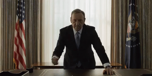 Man in Suit at Desk in Front of Window