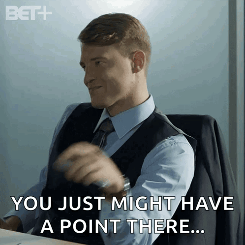 Man in Suit at Desk Saying You Just Might Have a Point There
