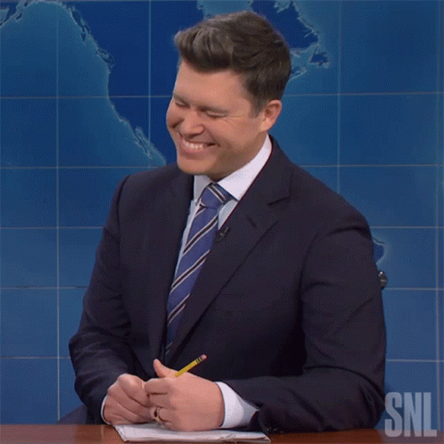 Man In Suit At Desk With SNL Logo GIF