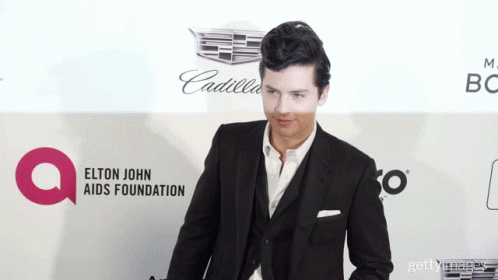Man In Suit At Elton John AIDS Foundation Banner GIF