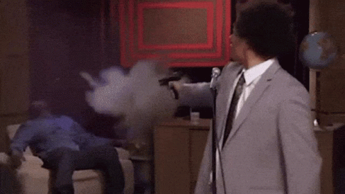Man In Suit At Mic Man On Couch GIF