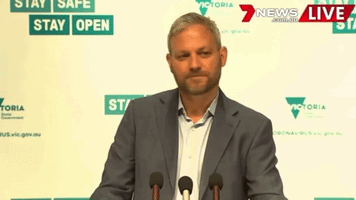 Man In Suit At Podium Saying Stay Safe GIF