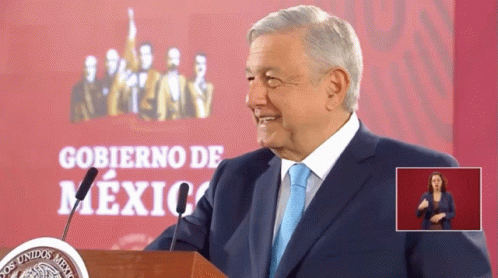 Man in Suit at Podium with Gobierno De Mexico Sign