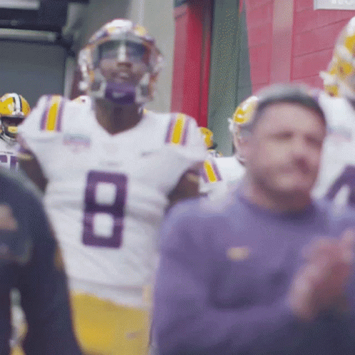 Man in Suit at Podium with LSU Sign