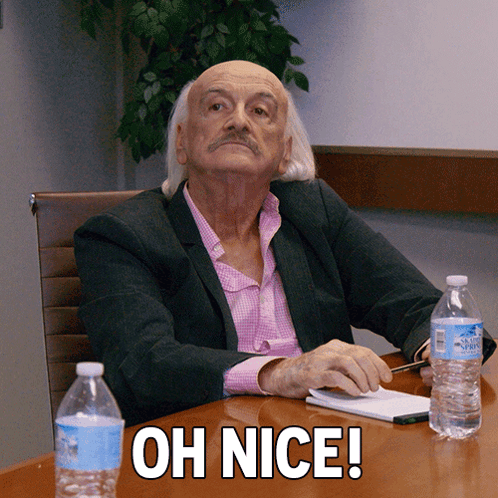 Man in Suit at Table Saying Oh Nice