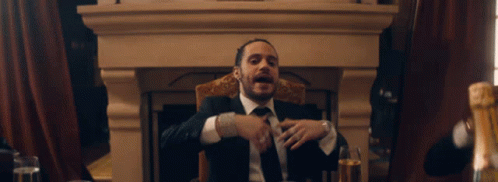 Man In Suit At Table With Champagne Glasses GIF